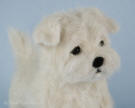 A close-up view of the needle felted Maltese puppy.
