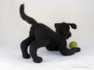 Felt statue of Lucy the black Lab with a tennis ball, facing back right
